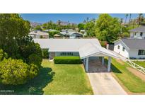 Charming single-story home with a well-maintained lawn and convenient covered parking at 4140 E Glenrosa Ave, Phoenix, AZ 85018