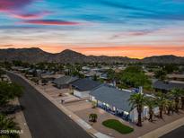 Scenic aerial view of a residential area with mountain backdrop and stunning sunset sky at 4252 E Zia St, Phoenix, AZ 85044