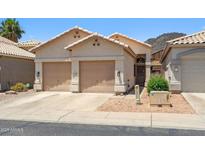 Charming single-story home with a two-car garage and desert landscaping for low-maintenance living at 4918 W Wahalla Ln, Glendale, AZ 85308