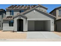 A two-story gray home with an open garage and a desert-style landscape offering modern living at 5439 S 251St Dr, Buckeye, AZ 85326