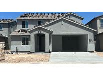 New two-story home features a gray stucco exterior, arched entryway, two car garage, and a stacked tile roof at 5439 S 251St Dr, Buckeye, AZ 85326