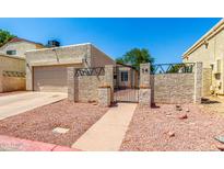 Charming front exterior featuring a private entrance with gated courtyard and attached garage at 619 E Jensen St # 14, Mesa, AZ 85203