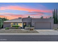 Charming single-story home featuring a two-car garage, gravel landscaping, and stylish architectural details at 6717 E Aire Libre Ln, Scottsdale, AZ 85254