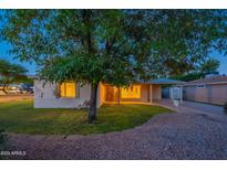 Charming single-story home featuring mature landscaping and a well-maintained front yard at dusk at 7035 N 11Th Pl, Phoenix, AZ 85020