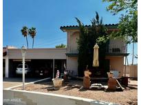 Inviting two-story home featuring a covered car port, balcony, and charming outdoor seating area at 7607 E Bonita Dr, Scottsdale, AZ 85250