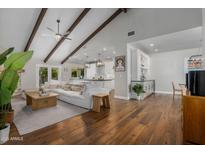 Open concept living room featuring vaulted ceiling, exposed beams, hardwood floors, and modern furnishings at 8343 E Quarterhorse Trl, Scottsdale, AZ 85258