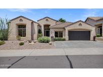 Charming single-story home featuring stucco exterior, desert landscaping, and a two-car garage at 10310 N 135Th Way, Scottsdale, AZ 85259