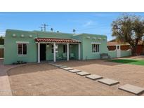 Charming home featuring a front porch with seating and desert landscaping at 1613 W Flower N Cir, Phoenix, AZ 85015