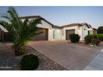 Charming home with a paver driveway, mature landscaping, and a two-car garage at 21120 E Superstition Dr, Queen Creek, AZ 85142