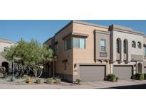 Modern townhome with a private garage and well-maintained desert landscaping enhancing the curb appeal at 23083 N 74Th Pl, Scottsdale, AZ 85255