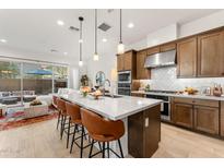 Bright kitchen featuring a large island, pendant lighting, and a seamless flow into the living area and outdoor patio at 23083 N 74Th Pl, Scottsdale, AZ 85255