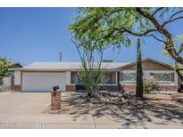Charming single-story home with a well-manicured desert landscape, mature trees, and a two-car garage at 2432 W Echo Ln, Phoenix, AZ 85021