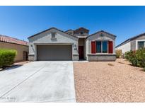 Charming single-story home features a two-car garage and desert landscaping at 30938 W Mitchell Dr, Buckeye, AZ 85396