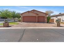 Charming home featuring a three car garage, brick driveway and beautifully landscaped yard with stone accents at 3215 E Constance Way, Phoenix, AZ 85042
