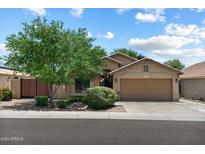 Charming home exterior with mature tree, two car garage and neutral color palette at 3911 W Quail Ave, Glendale, AZ 85308