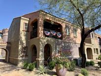 Inviting two-story condo featuring a balcony with festive decorations and colorful landscaping at 3935 E Rough Rider Rd # 1066, Phoenix, AZ 85050