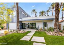 Modern home's exterior features professionally landscaped yard, walkway, with architectural trees and desert foliage at 4312 E Roma Ave, Phoenix, AZ 85018