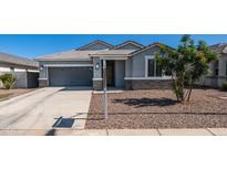 Charming single-story home featuring a well-maintained front yard, gray stucco, and a two-car garage at 44232 W Palo Cedro Rd, Maricopa, AZ 85138