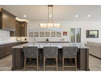 Modern kitchen with a large center island, white countertops, dark wood cabinets, and stainless steel appliances at 5332 E Thunder Hawk Rd, Cave Creek, AZ 85331
