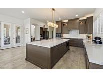 Open kitchen featuring a large island with white marble countertops, stylish cabinets, and modern stainless appliances at 5332 E Thunder Hawk Rd, Cave Creek, AZ 85331