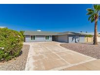 Charming single-story home with a well-manicured front yard and spacious driveway on a bright day at 12021 S Tomi Dr, Phoenix, AZ 85044
