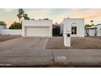 Charming single-story home featuring a two-car garage, gated front entry, and low-maintenance desert landscaping at 14029 N Burning Tree Pl, Phoenix, AZ 85022