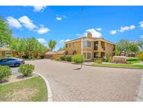 A well-maintained condo building with desert landscaping, a circular drive, and signage for The Legacy community at 1411 E Orangewood Ave # 237, Phoenix, AZ 85020