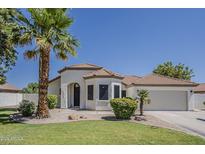 Charming single-story home with a well-manicured lawn, mature palm trees, and a two-car garage at 1444 E Boston St, Chandler, AZ 85225