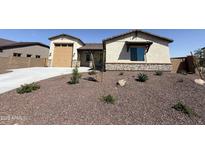 Inviting single-Gathering home with low-maintenance desert landscaping and charming exterior details at 17304 W Royal Palm Rd, Waddell, AZ 85355