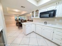 Bright kitchen featuring white cabinetry, modern appliances, and tile flooring at 17404 N 99Th Ave # 126, Sun City, AZ 85373