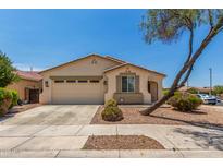 Charming single-story home featuring a two-car garage, desert landscaping, and a beige stucco facade under a sunny blue sky at 17649 W Buchanan St, Goodyear, AZ 85338