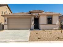 Tan single-Gathering home with a two-car garage and low-maintenance landscaping at 18354 W Patrick Ln, Surprise, AZ 85387