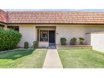 Charming single-story home featuring a well-manicured lawn, desert landscaping, and a classic red tile roof at 25 N Cottonwood St # 47, Chandler, AZ 85225