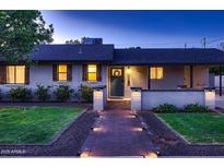 Charming single story home featuring a brick walkway, trimmed bushes, and a wreath on the front door at 2518 E Flower E St, Phoenix, AZ 85016
