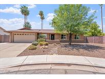Charming single-story home with a well-manicured yard, desert landscaping, and attached two-car garage at 2727 W Ocaso Cir, Mesa, AZ 85202