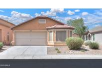 Inviting single-story home with a neutral color scheme, well-maintained landscaping, and an attached two-car garage at 40468 W Sanders Way, Maricopa, AZ 85138