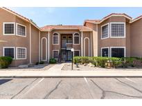 Two-story condo building with desert landscaping, a red tile roof, and private entry stairs at 5230 E Brown Rd # 114, Mesa, AZ 85205