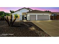 Charming single-story home boasts a tiled roof, two-car garage, and well-maintained desert landscaping at 6935 W Monte Lindo St, Glendale, AZ 85310
