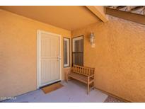 Inviting condo front entrance with a charming wooden bench, fresh paint, and ample natural light at 8787 E Mountain View Rd # 1110, Scottsdale, AZ 85258