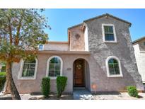 Charming two-story home featuring arched windows, a decorative front door, and well-maintained landscaping at 10136 E Isleta Ave, Mesa, AZ 85209