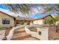 Charming home exterior with stone walkway, desert landscaping, and a warm, inviting facade at 10523 E Sleepy Hollow Trl, Gold Canyon, AZ 85118