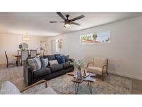 Bright living room featuring neutral tones, stylish furnishings, and a view into the dining area at 1466 E Nielson Ave, Mesa, AZ 85204