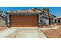 Charming single-story home showcasing a two-car garage and well-maintained desert landscaping at 14936 W Maui Ln, Surprise, AZ 85379