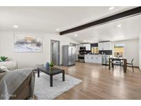 Open-concept living area featuring a modern kitchen with stainless steel appliances and a cozy seating area at 16523 N Queen Esther Dr, Surprise, AZ 85378