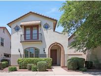 Charming two-story home with an arched entryway, small balcony, and well-maintained landscaping at 20545 W Terrace Ln, Buckeye, AZ 85396