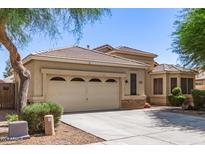 Beige home featuring a two-car garage, tile roof, and desert landscaping at 20895 E Via Del Rancho Rd, Queen Creek, AZ 85142