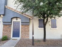 Charming townhouse features a blue front door, stone accents, and mature trees for added curb appeal at 2402 E 5Th St # 1472, Tempe, AZ 85288