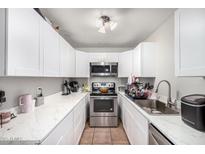 Efficient kitchen with white cabinets, stainless steel appliances, and marble countertops for a modern look at 3646 N 67Th Ave # 29, Phoenix, AZ 85033
