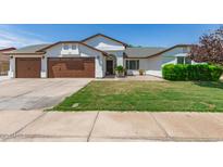 Charming home featuring a three-car garage, well-maintained lawn, and covered entry at 6232 N 88Th Ave, Glendale, AZ 85305