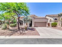 Charming single-story home with desert landscaping, mature trees, and a two-car garage at 7532 E Sierra Morena Cir, Mesa, AZ 85207
